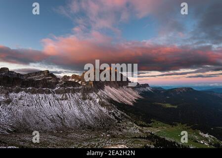 Nuvole, scogliere e le cime dei monti Puez-Odle al crepuscolo rosso all'alba sulle Dolomiti, sulla valle del Villnöß, sul Tirolo, Italia Foto Stock