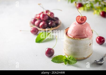 Ciotola di gelato alla ciliegia con frutti di bosco freschi su sfondo bianco Foto Stock