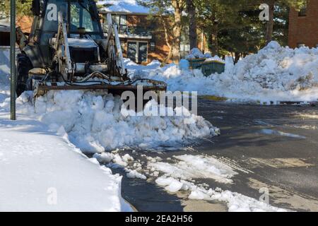 Diversi carrelli di pulizia sono l'asfalto del parcheggio per auto neve invernale sullo sfondo Foto Stock