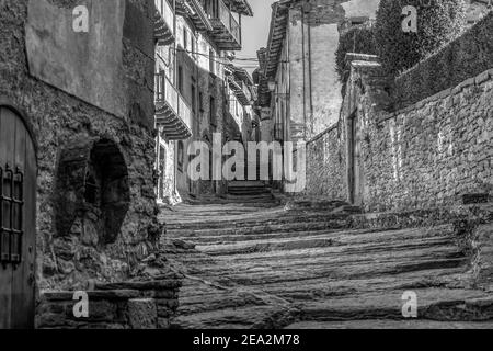 Incredibile vista della vecchia strada di pietra naturale con una fontana in antico borgo medievale di Rupit, Barcellona, Spagna. Bianco e nero foto stile, vintage Foto Stock