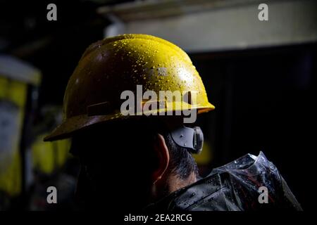 (210207) -- URUMQI, 7 febbraio 2021 (Xinhua) -- l'infiltrazione della montagna all'interno del tunnel cade sul casco di un operaio nel sito di costruzione del tunnel di Tianshan Shengli nella regione autonoma di Xinjiang Uygur, 4 febbraio 2021. Il tunnel di Tianshan Shengli, con una lunghezza totale di circa 22 chilometri, è attualmente il tunnel autostradale più lungo in costruzione in Cina. Iniziato nel 2020, il tunnel, un progetto di sei anni sulla strada statale Urumqi-Yuli, passa attraverso una zona fredda e ad alta quota, con condizioni climatiche e geologiche difficili. Dopo il completamento e aperto al traffico, fornirà Foto Stock