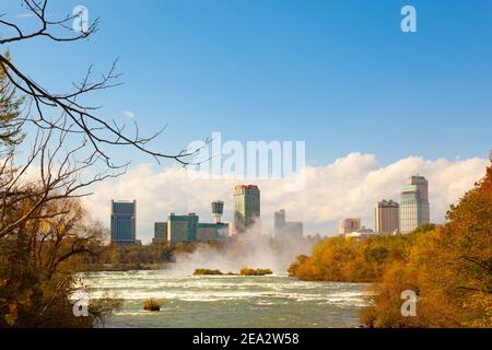 Fiume Niagara in autunno. Confine tra Stati Uniti e Canada. Sullo sfondo grattacieli del Canada. Nella parte anteriore ci sono alberi gialli Foto Stock
