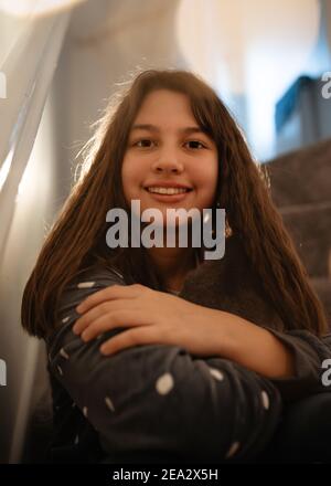 Ragazze in pigiami grigi che si siedono su una sulle scale Foto Stock