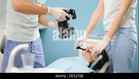 Dentista che fotografa il risultato del suo lavoro Foto Stock