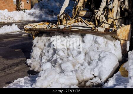 La rimozione di neve sulla strada nel parcheggio per auto neve invernale sullo sfondo Foto Stock