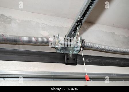 Molle tensionano il meccanismo della porta del garage domestico, vista dall'interno, rotaia visibile con catena. Foto Stock