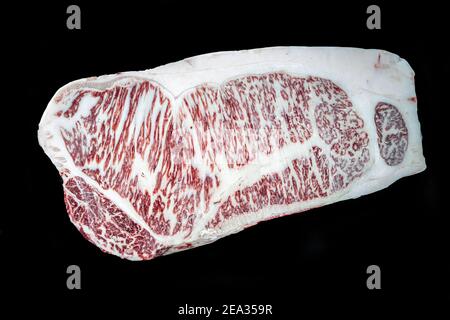 Pezzo di bistecca di manzo di Wagyu. Bistecca di manzo crudo su sfondo nero. Prodotto giapponese premium. Foto Stock