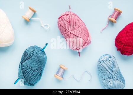 Uncini multicolore con palle di filato su un blu sfondo Foto Stock