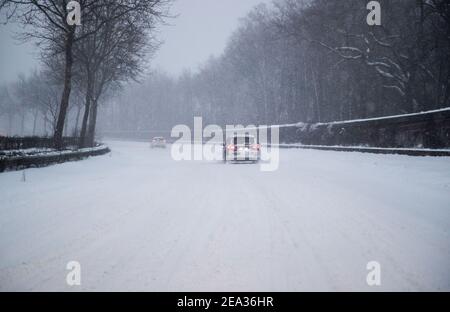 Bielefeld, Germania. 07 febbraio 2021. Solo poche auto guidano su una strada innevata. Credit: Friso Gentsch/dpa/Alamy Live News Foto Stock