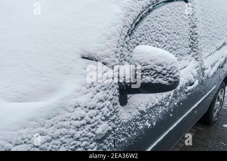 Parabrezza / parabrezza / parabrezza / parabrezza di stazionamento auto coperta di neve durante le basse temperature in inverno Foto Stock