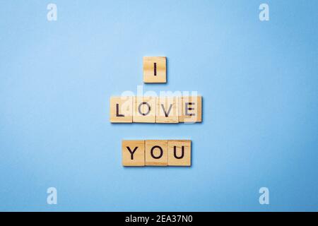 L'iscrizione su cubi di legno ti amo, steso su sfondo blu, vista dall'alto Foto Stock