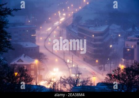 Bielefeld, Germania. 07 febbraio 2021. Automobili che guidano su una strada innevata al crepuscolo. Scatto con esposizione prolungata. Credit: Friso Gentsch/dpa/Alamy Live News Foto Stock