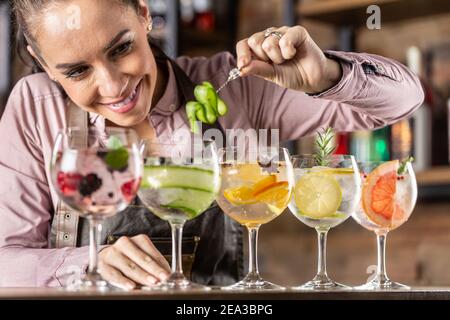 Il barman serve cocktail gin tonic estivi presso un bar. Foto Stock