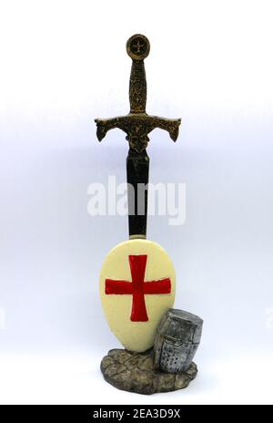 Foto di un ornamento in metallo con un cavaliere di spada in casco e scudo con la croce di San Giorgio su sfondo bianco Foto Stock