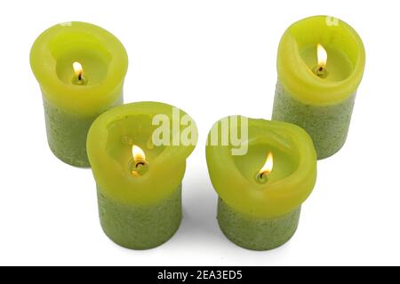 candele verdi brucianti di diverse dimensioni su sfondo bianco, vista dall'alto Foto Stock