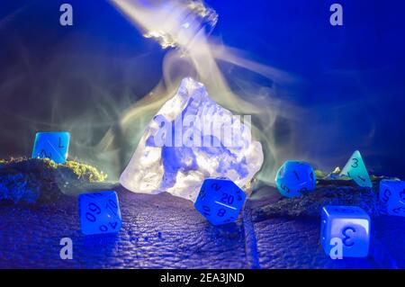Scena RPG di un cristallo di sale retroilluminato e rpg blu dadi su una superficie in pelle Foto Stock