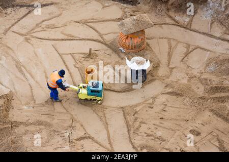 vista aerea di un lavoratore con un compattatore in costruzione sito Foto Stock