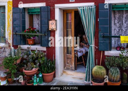 Burano, Venezia, Italia, 2020 settembre – una vecchia donna che ricama un merletto in una casa tipica di Burano Foto Stock