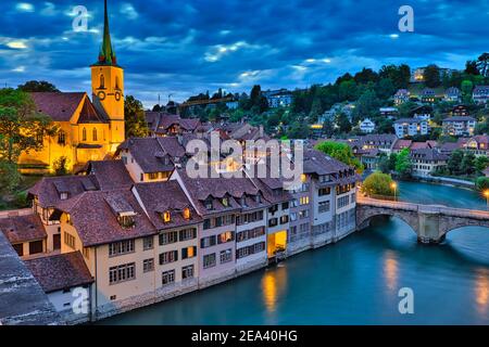 Skyline di Berna, capitale della Svizzera all'ora blu che si riflette nel fiume Aare. Vista panoramica sulla città vecchia, sulla chiesa di Nydegg e sul ponte Untertorbrucke Foto Stock