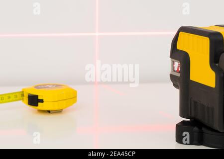 linee sulla parete contrassegnate da un laser elettronico utilizzato per determinare gli angoli durante le misure di costruzione e le lavorazioni di finitura interna Foto Stock