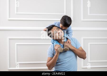 Padre e figlio messicani giocano felicemente a casa Foto Stock