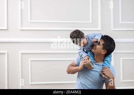 Padre e figlio messicani giocano felicemente a casa Foto Stock