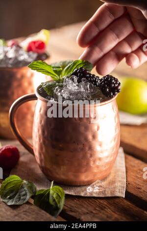 Il cocktail vodka a palle di mula a bacca di Mosca è una bevanda lunga con succo di lime fresco, birra allo zenzero e frutti di bosco. Foto Stock