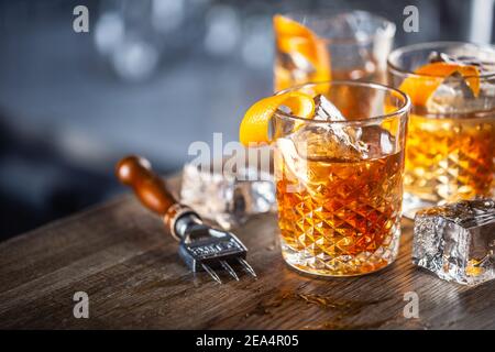 Classico cocktail al rum vecchio stile su ghiaccio con guarnitura a scorza d'arancia. Foto Stock