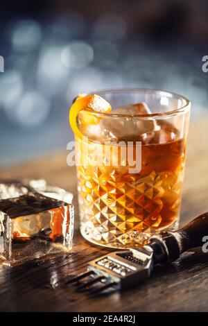 Bevanda al rum vecchio stile su ghiaccio con guarnitura a scorza d'arancia. Foto Stock