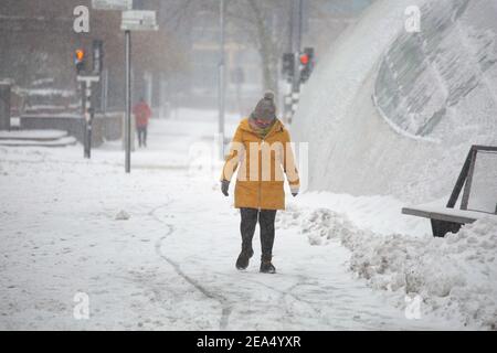 Una donna che cammina sulla strada innevata in piazza Septemberplein 18. Blizzard dalla tempesta di neve Darcy colpisce i Paesi Bassi, la prima nevicata pesante con forti venti intensi dopo il 2010. Il paese si svegliò domenica con uno strato di neve che copriva tutto. Molti incidenti si sono verificati sulle strade olandesi a causa della tempesta e delle condizioni di ghiaccio, mentre c'era un problema anche con i treni. Nella città di Eindhoven, nel nord del Brabant, i servizi ferroviari e di autobus hanno smesso di funzionare, l'aeroporto ha seguito e il traffico aereo è stato deviato. La gente è andata fuori nel centro della città di Eindhoven per godersi lo scenario bianco Foto Stock