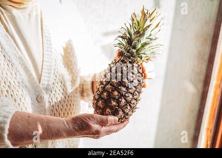 Mani femminili che tengono un ananas. Frutta fresca e tropicale Foto Stock