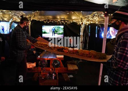 Philadelphia, Stati Uniti. 7 Feb 2021. Una cheesesteak Philly lunga cinque piedi viene portata a un tavolo da pranzo all'aperto al Tradeesman's, un bar e ristorante, con Super Bowl LV che gioca alla televisione a Philadelphia, USA. Credit: Chase Sutton/Alamy Live News Foto Stock