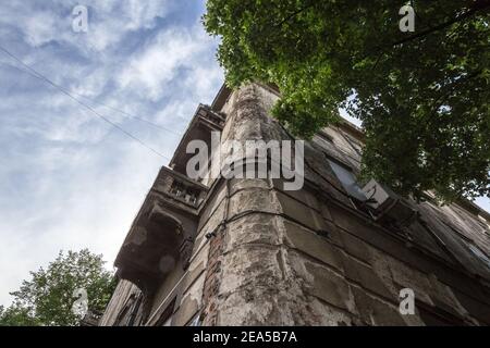 Cerotto da peeling Damged all'angolo di un vecchio edificio residenziale con mura in declino nel centro di Belgrado, Serbia, che ha bisogno di una pesante ristrutturazione. PICT Foto Stock