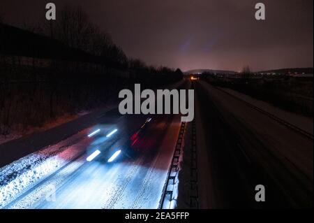 Himbergen, Germania. 8 febbraio 2021. Un carrello si muove sull'autostrada A30 parzialmente cancellata. In bassa Sassonia, si prevede che la nevicata si attenuerà inizialmente durante la notte fino a lunedì, ma si prevede che nuovi fiocchi si sposteranno dal sud nelle ore mattutine. Credit: Jonas Walzberg/dpa/Alamy Live News Foto Stock