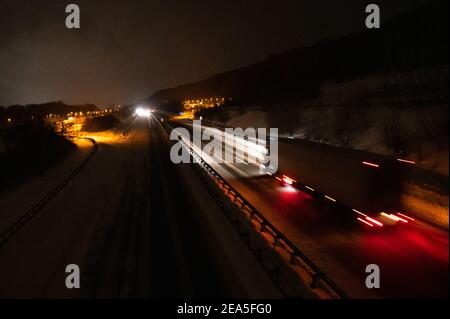 Himbergen, Germania. 8 febbraio 2021. Un carrello si muove sull'autostrada A30 parzialmente cancellata. In bassa Sassonia, si prevede che la nevicata si attenuerà inizialmente durante la notte fino a lunedì, ma si prevede che nuovi fiocchi si sposteranno dal sud nelle ore mattutine. Credit: Jonas Walzberg/dpa/Alamy Live News Foto Stock