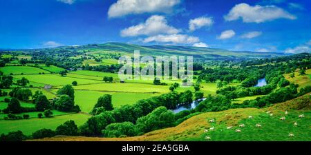 Panorama meandering fiume che si fa strada attraverso lussureggiante verde campagna terreni agricoli nella calda luce del sole precoce. Foto Stock