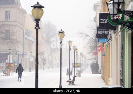 Potsdam, Germania. 07 febbraio 2021. Un uomo cammina nella neve attraverso la zona pedonale vuota di Brandenburger Straße. Credit: Soeren Stache/dpa-Zentralbild/dpa/Alamy Live News Foto Stock