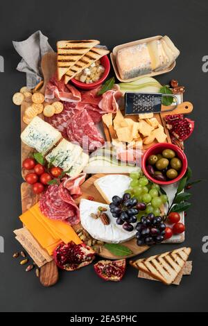 Tavola degli antipasti. Formaggio, fusit e cartone di carne su sfondo scuro. Vista dall'alto Foto Stock