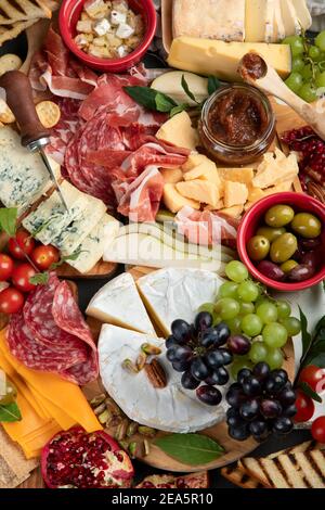 Tavola degli antipasti. Formaggio, fusit e cartone di carne su sfondo scuro. Vista dall'alto Foto Stock
