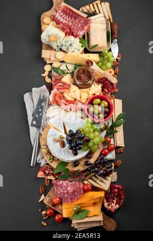 Tavola degli antipasti. Formaggio, fusit e cartone di carne su sfondo scuro. Vista dall'alto con spazio per la copia Foto Stock