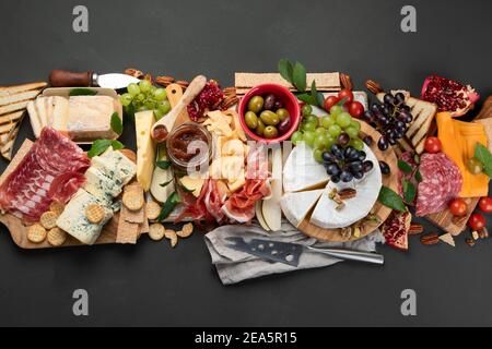 Tavola degli antipasti. Formaggio, fusit e cartone di carne su sfondo scuro. Vista dall'alto con spazio per la copia Foto Stock