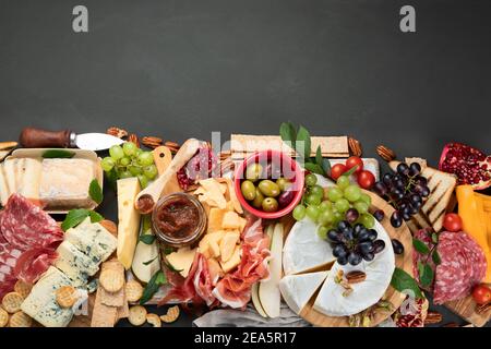 Tavola degli antipasti. Formaggio, fusit e cartone di carne su sfondo scuro. Vista dall'alto con spazio per la copia Foto Stock