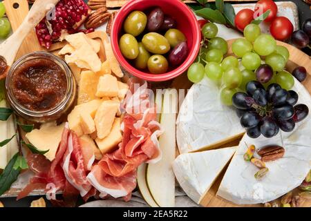 Tavola degli antipasti. Formaggio, fusit e cartone di carne su sfondo scuro. Vista dall'alto Foto Stock