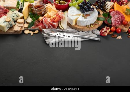 Tavola degli antipasti. Formaggio, fusit e cartone di carne su sfondo scuro. Spazio di copia Foto Stock