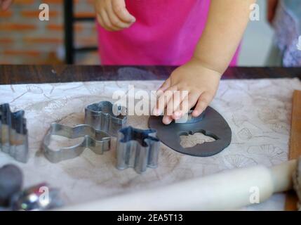 Una giovane ragazza asiatica carina imparando a modellare l'argilla nella sua classe di ceramica, modellando l'argilla in un piatto e decorandola. Foto Stock