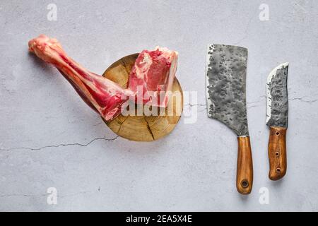 Vista dall'alto del dente fresco di cervo crudo con spezie e. erba su sfondo concreto Foto Stock