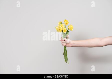 la mano dell'uomo tiene fuori un bouquet di fiori selvaggi e mostra un concetto di separazione di fico. layout con posto per il testo Foto Stock