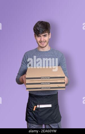 Fast food delivery uomo con scatole di pizza in mano che consegna l'ordine per la consegna, vestito in uniforme e sorridente Foto Stock
