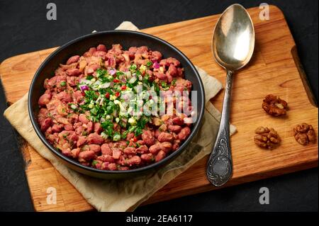 Lobion in ciotola nera sul piano d'ardesia dei squali. Cucina georgiana, stufato di fagioli. Foto Stock