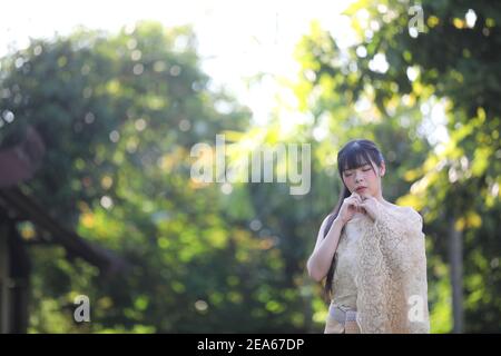 Ritratto di donna tailandese con abito tradizionale tailandese con tempio sfondo Foto Stock